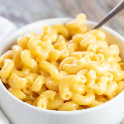 Square image of a white bowl filled with mac and cheese.