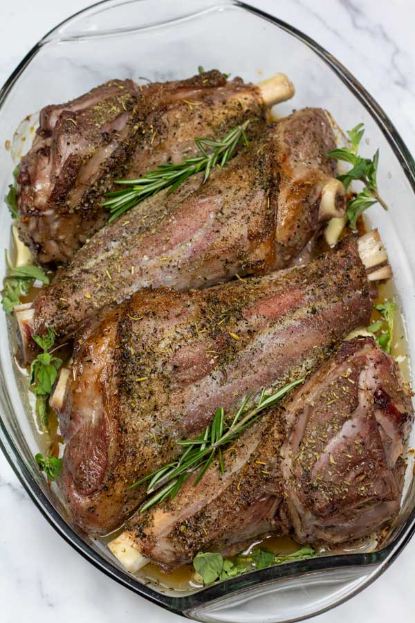 Process image 3 showing roasted lamb shanks with fresh herbs.