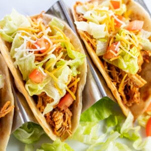 Square image of shredded chicken tacos.