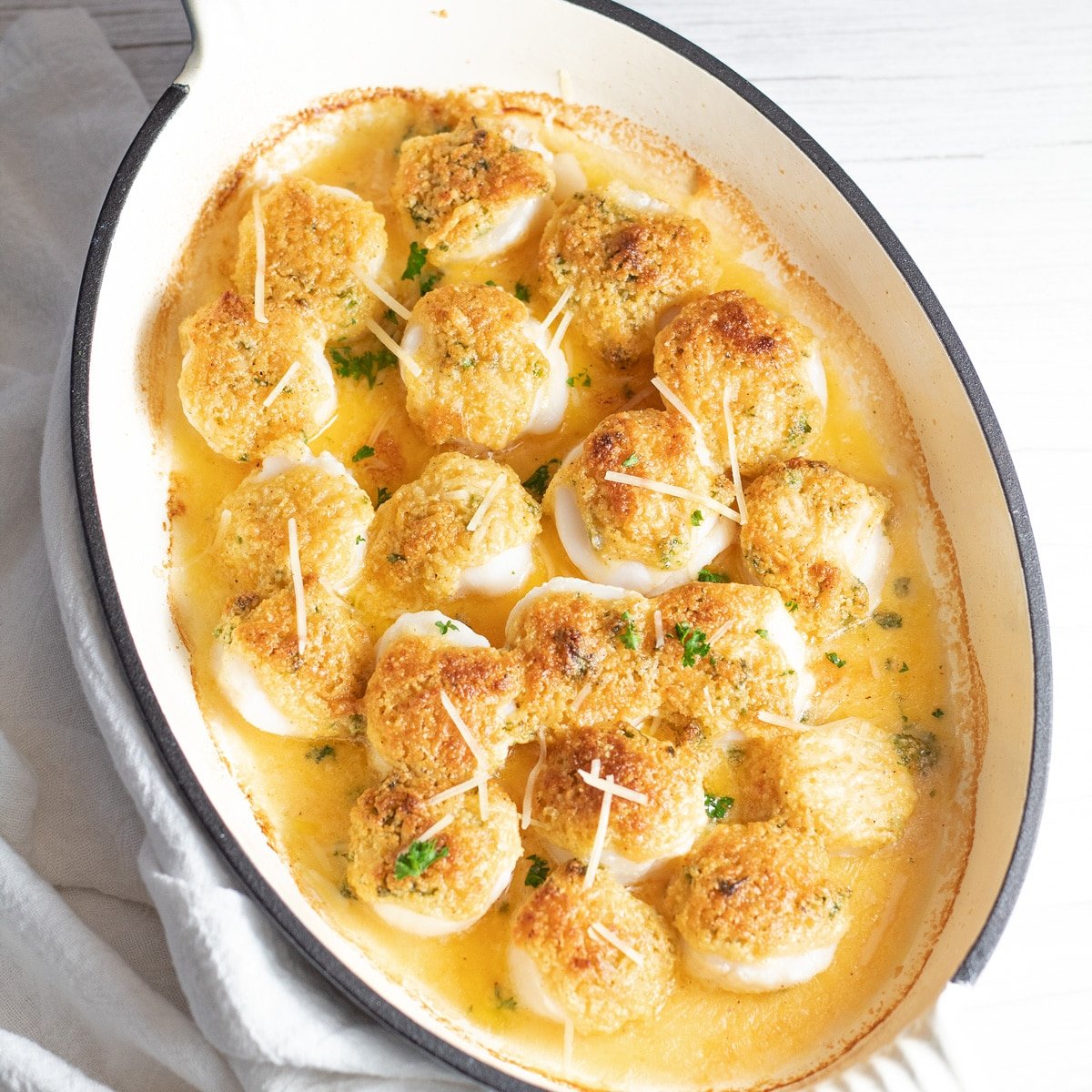 Best baked scallops topped with crumb topping in enamel coated cast iron baking dish.