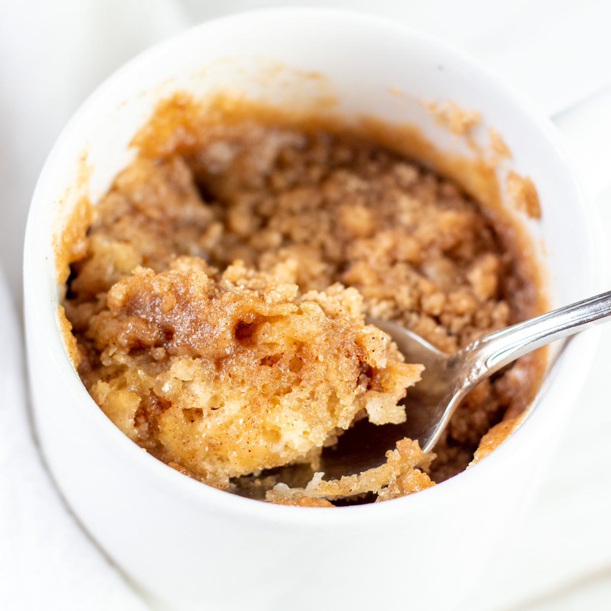 Tasty cinnamon coffee cake mug cake dessert after cooking for under 2 minutes in the microwave.