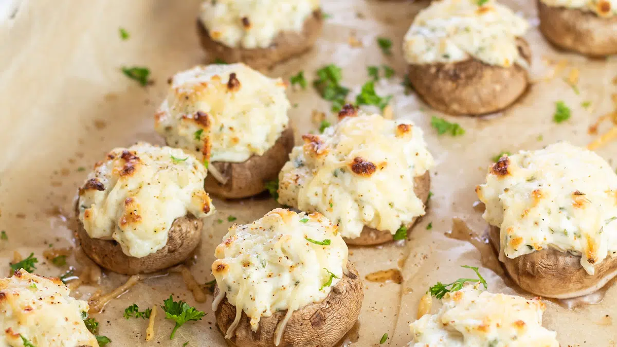 Wide closeup on the baked cream cheese stuffed mushrooms with toasted topping.