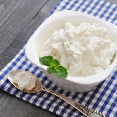 Best ricotta cheese substitute with ricotta in white bowl on blue checkered napkin.