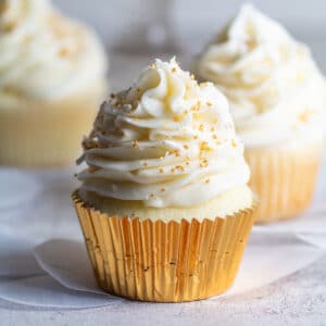 Tasty vanilla bean cupcakes topped with a towering amount of equally delicous vannila bean buttercream frosting.