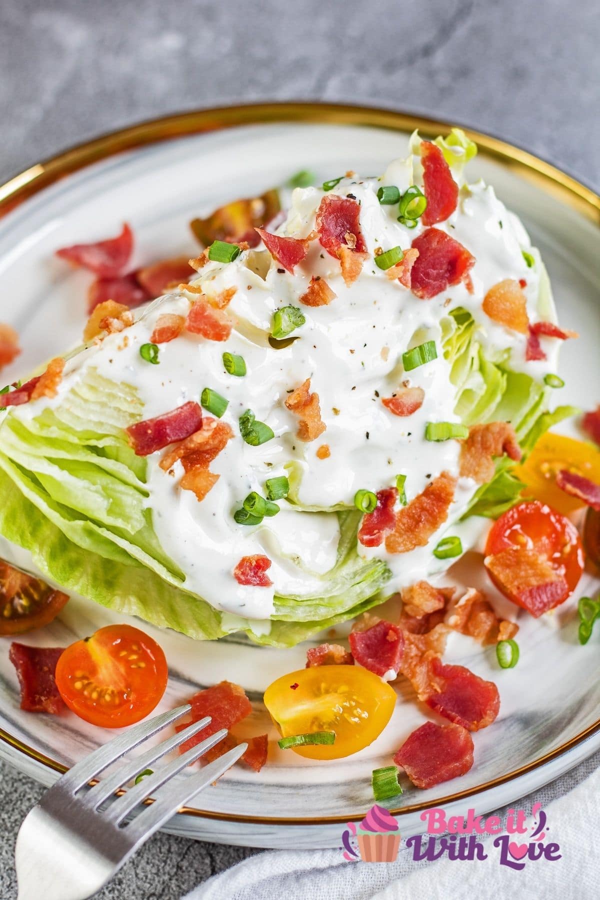 Iceberg wedge salad on marbled plate with classic toppings.