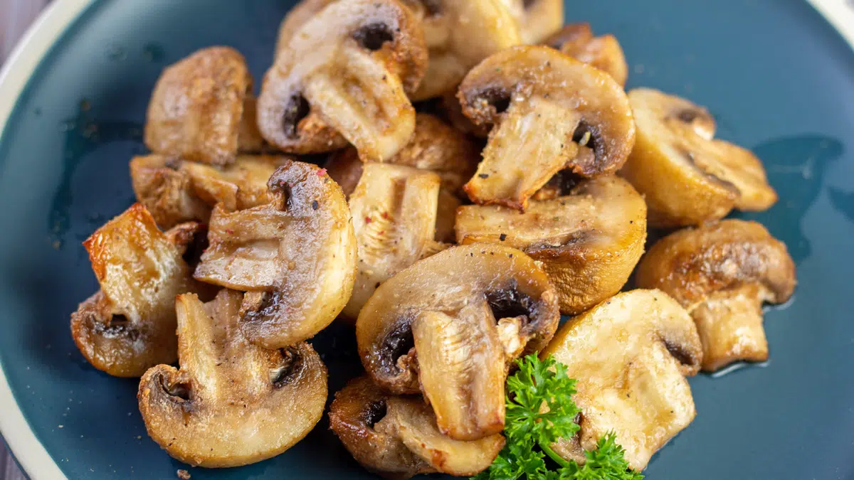 Wide image of air fryer mushrooms on a blue plate.