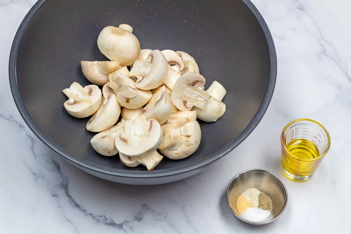 Overhead ingredient photo showing mushrooms, seasoning, and olive oil.