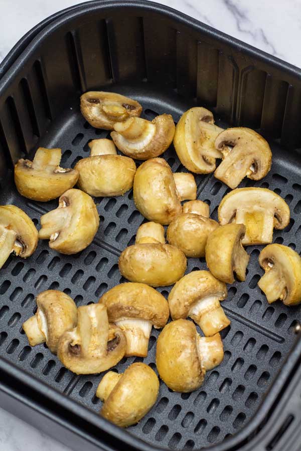 Process photo 3 showing mushrooms in the air fryer basket after air frying.