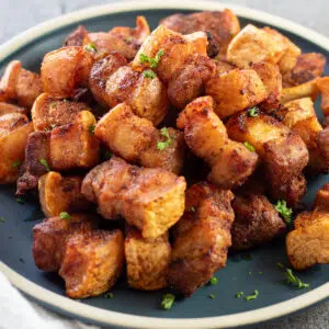 Closeup image of a plate of air fryer pork belly bites.
