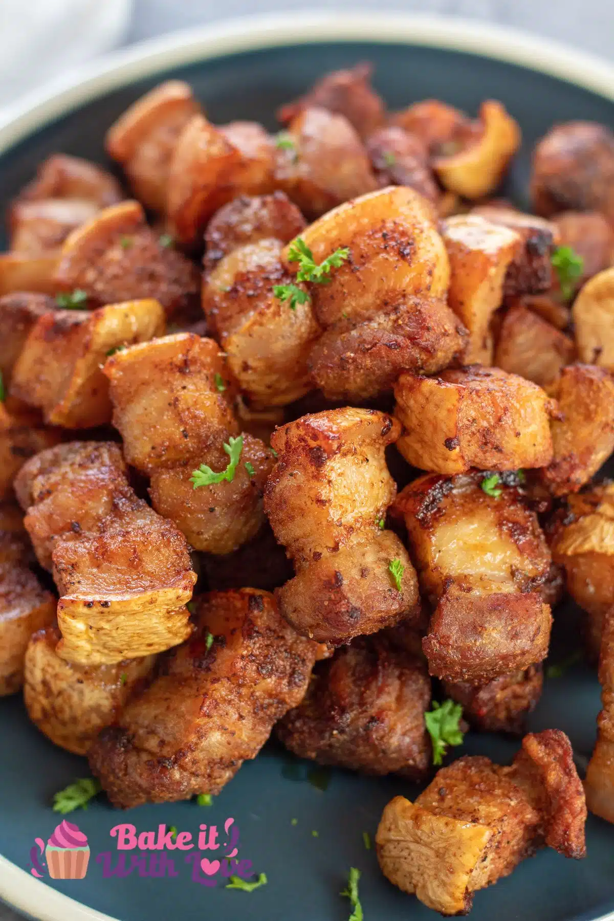 Tall image of a plate of air fryer pork belly bites.