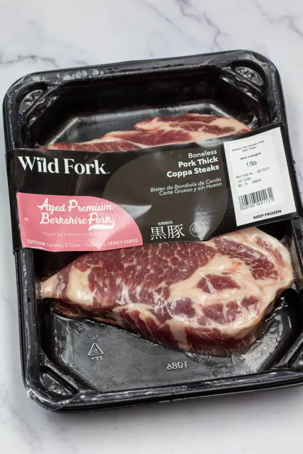 Ingredient photo showing packaged pork steaks.