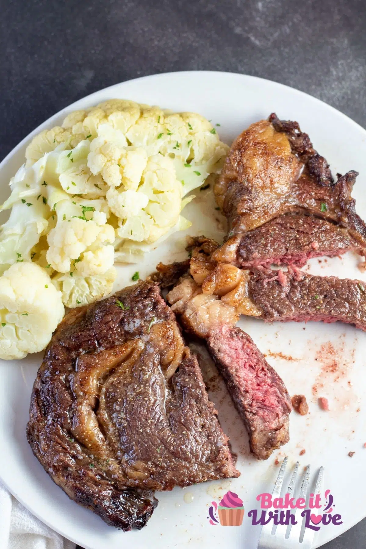 Tall overhead of the sliced air fryer steak plated with cauliflower.