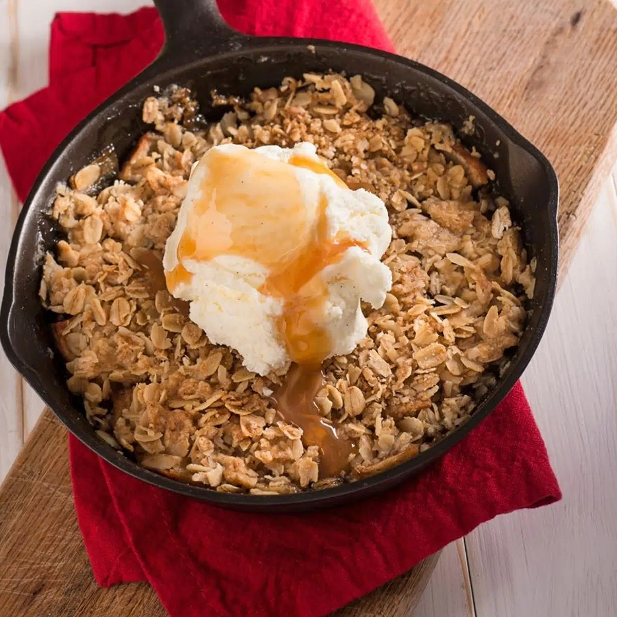 Square image of apple crisp in a cast iron pan.