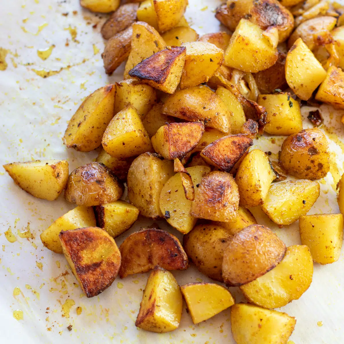 Square image of curry roasted potatoes on a baking sheet.