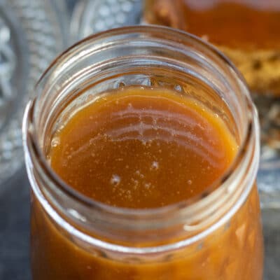 Square image of English toffee sauce in a glass jar.