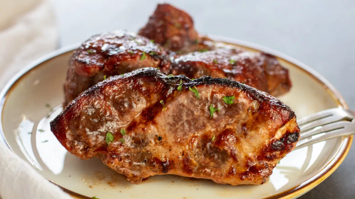 Wide image of intant pot bloneless country style pork ribs on a tan plate.