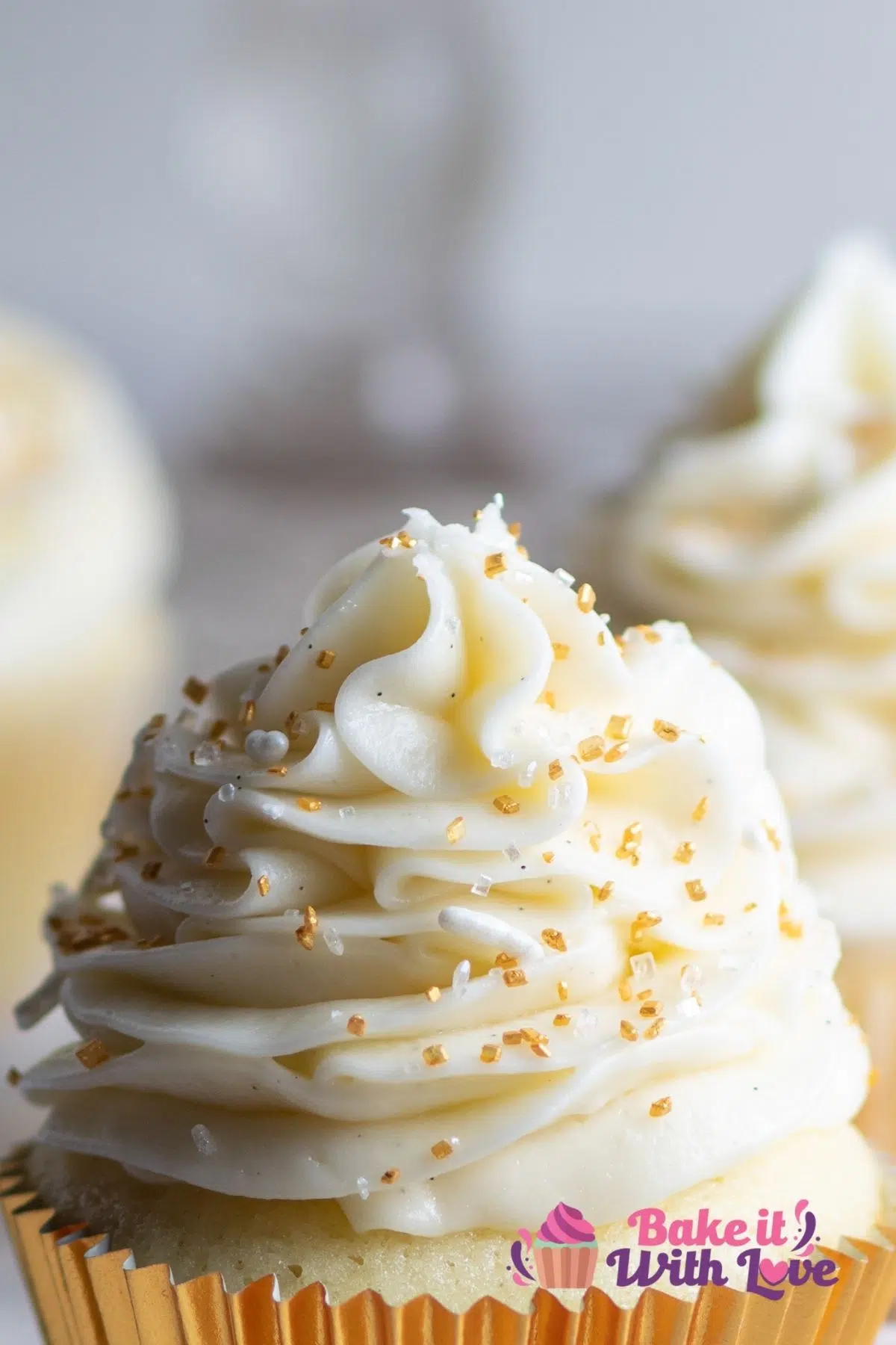 Tall closeup on the vanilla bean buttercream frosting piped high on top of vanilla cupcakes.