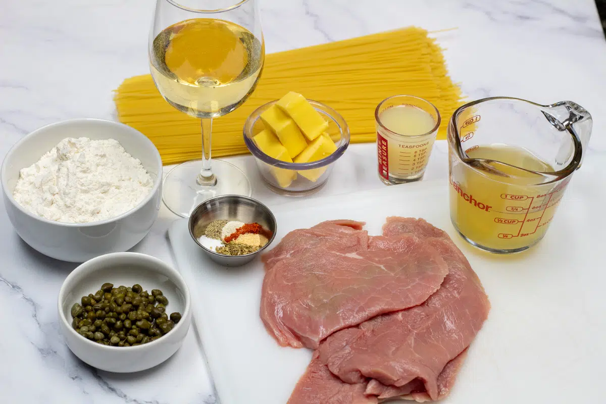 Wide image showing ingredients needed for veal scallopini.