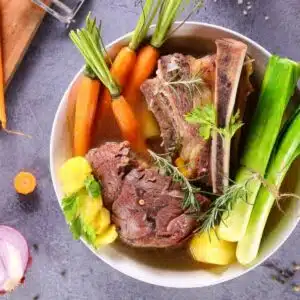Best beef broth substitutes with all the basics of making a great broth pictured on grey background.
