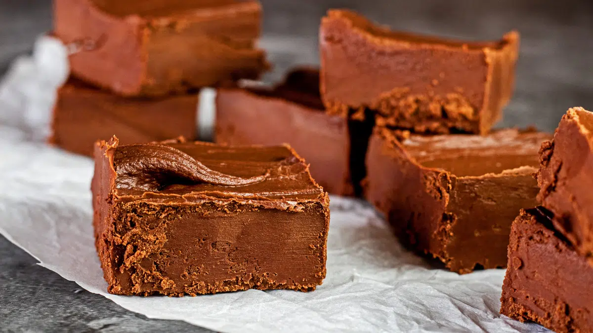 Wide closeup on the stacked squares of chocolate frosting fudge.