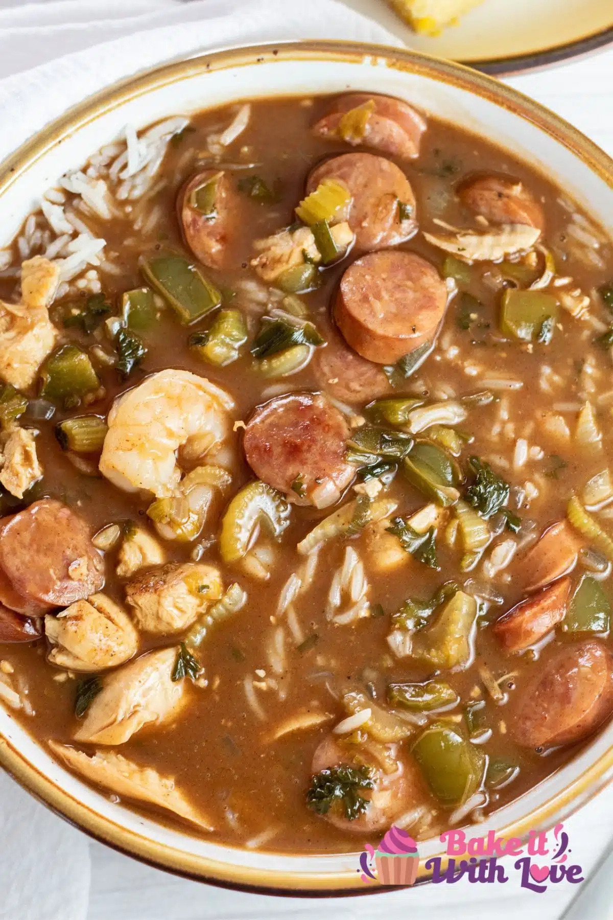 Tall overhead of the dished up gumbo soup with steamed white rice mixed in.