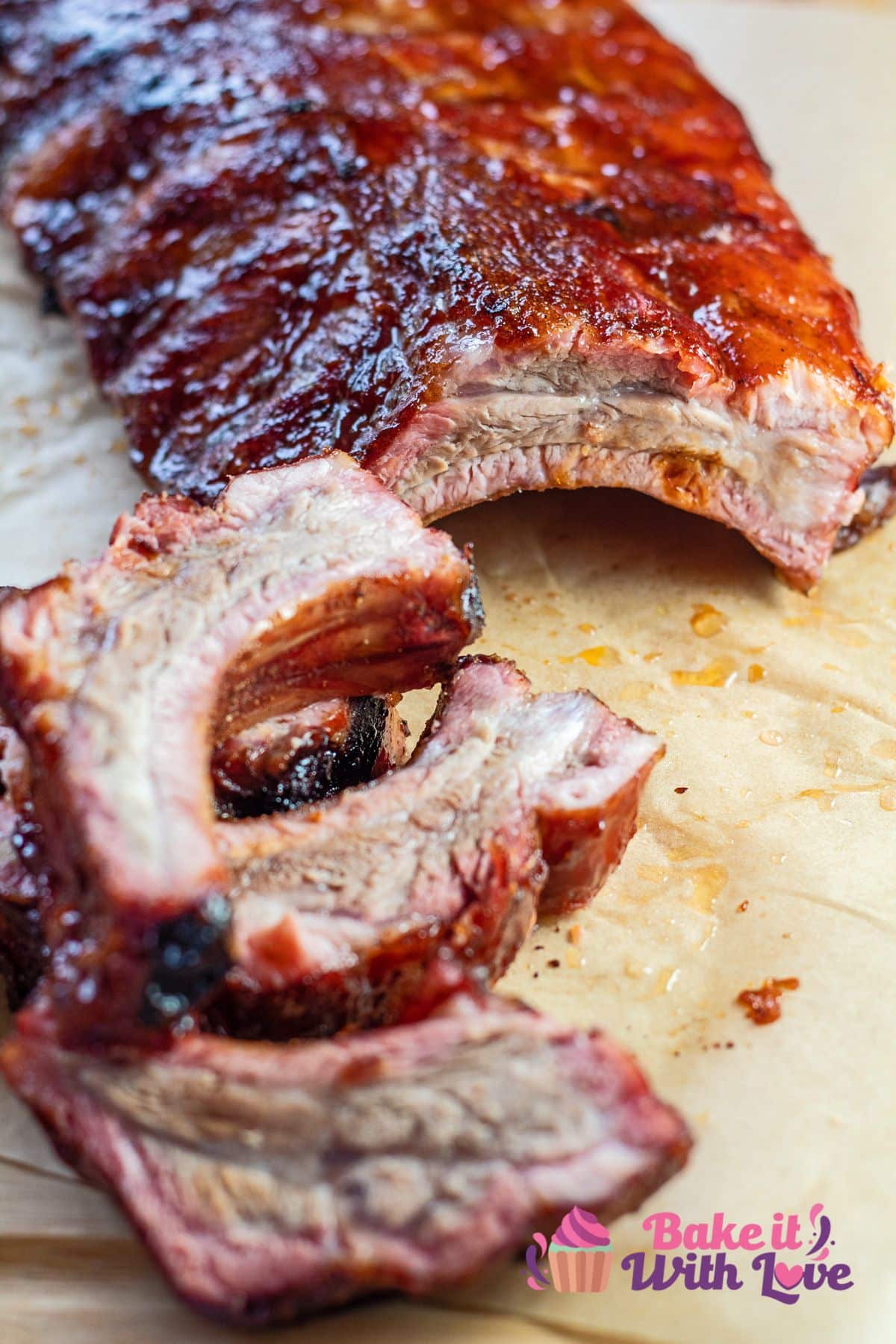 Tall closeup on the sliced smoked baby back ribs on cutting board.