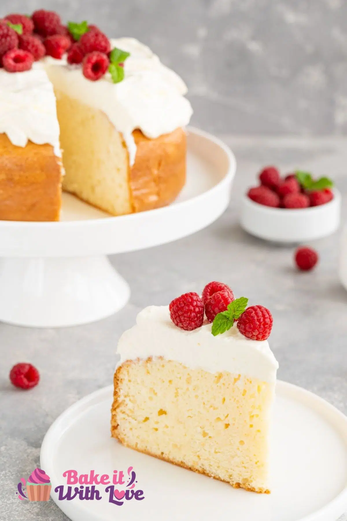 Tall image of the tres leches cake on cake stand with a slice pulled out and plated.