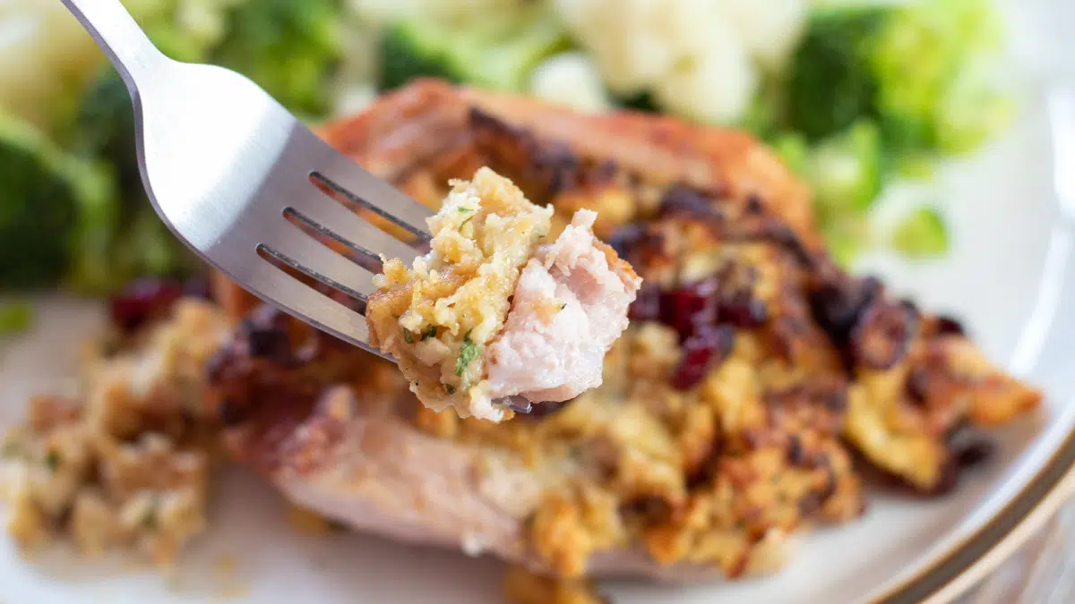 Wide closeup on the air fryer stuffed pork chops bite on a fork.