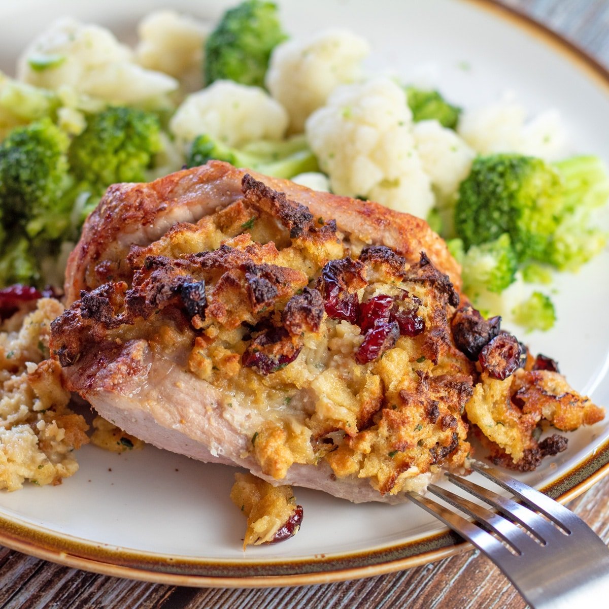 Tasty air fryer stuffed pork chops dished up with steamed veggies.