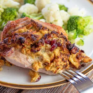 Closeup on the plated air fryer stuffed pork chops served with broccoli and cauliflower.