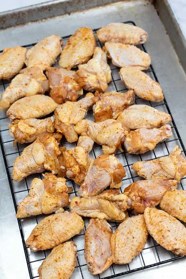 Process image 3 showing seasoned chicken wings on a baking sheet.