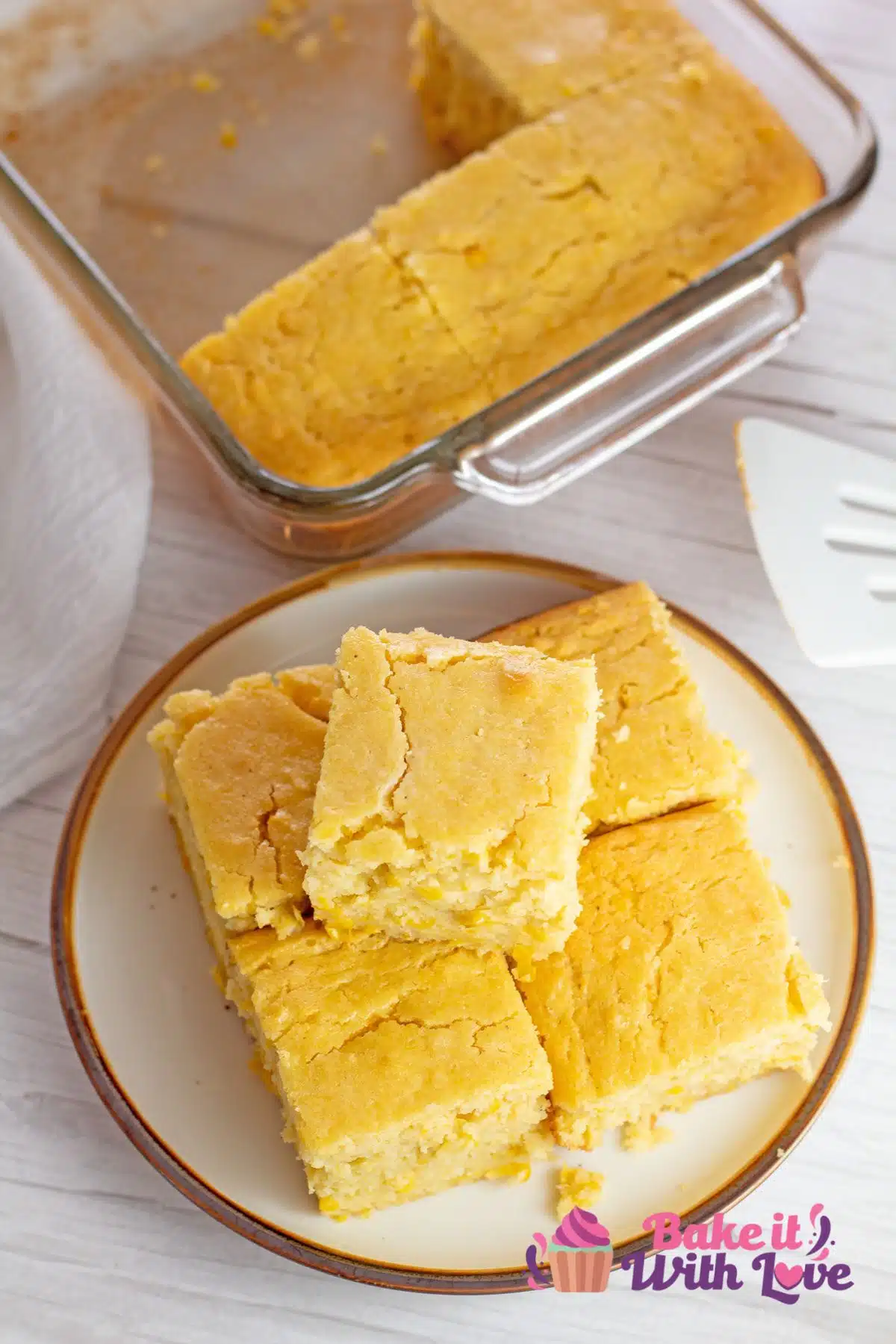 Best creamed corn cornbread overhead image of the stacked slices on a plate with baking dish next to them.