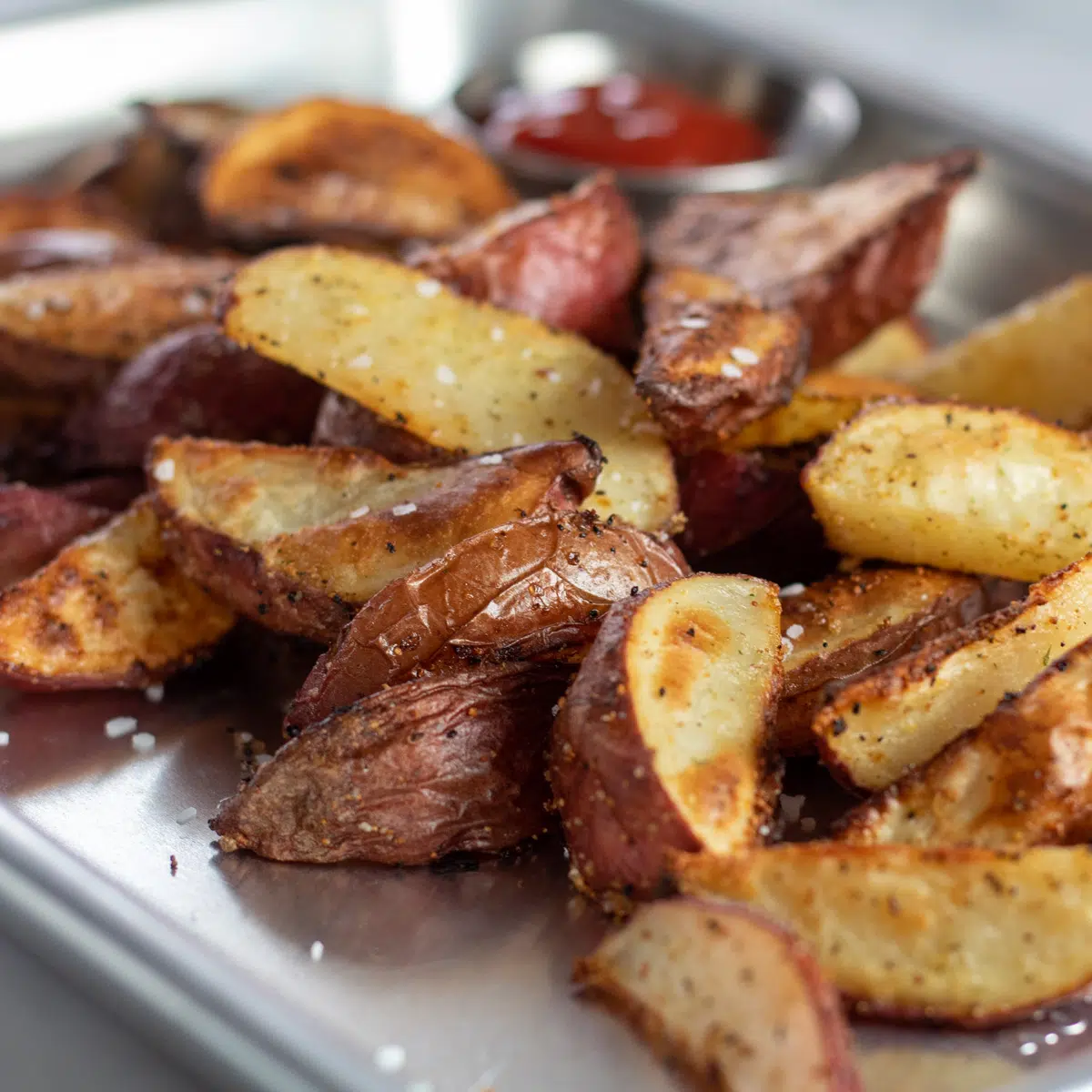 Квадратно изображение на печени резени червени картофи.