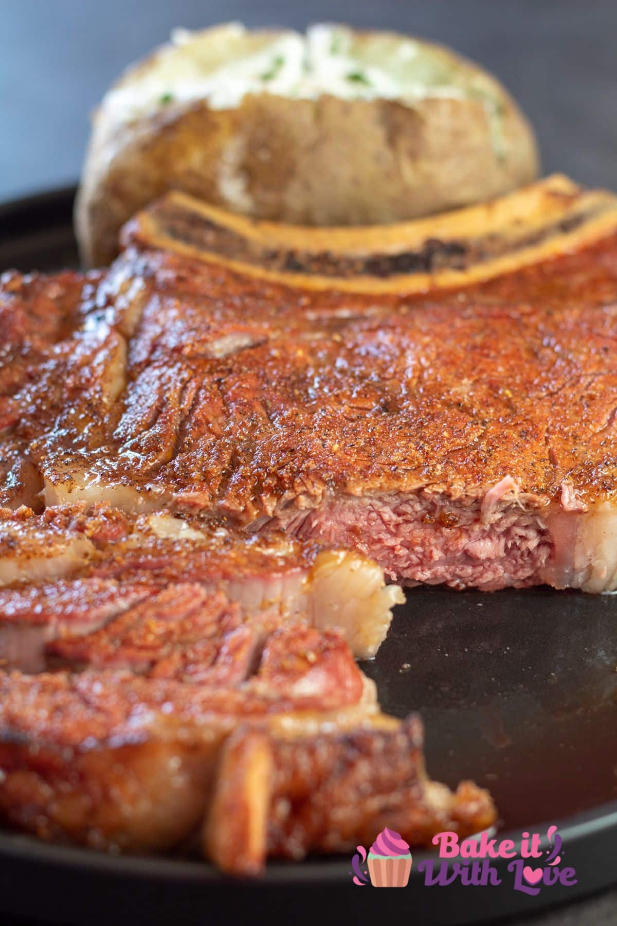 Best smoked ribeye steak cut into on black plate.