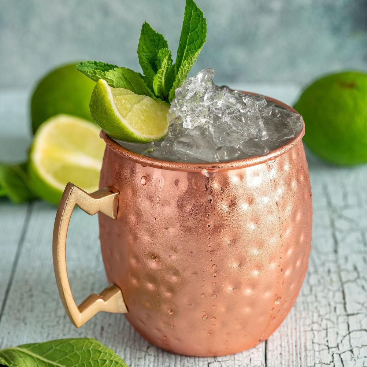 Refreshing, classic Moscow mule cocktail in copper mug with lime and mint.