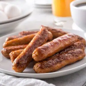 Square image of air fryer frozen sausage links.