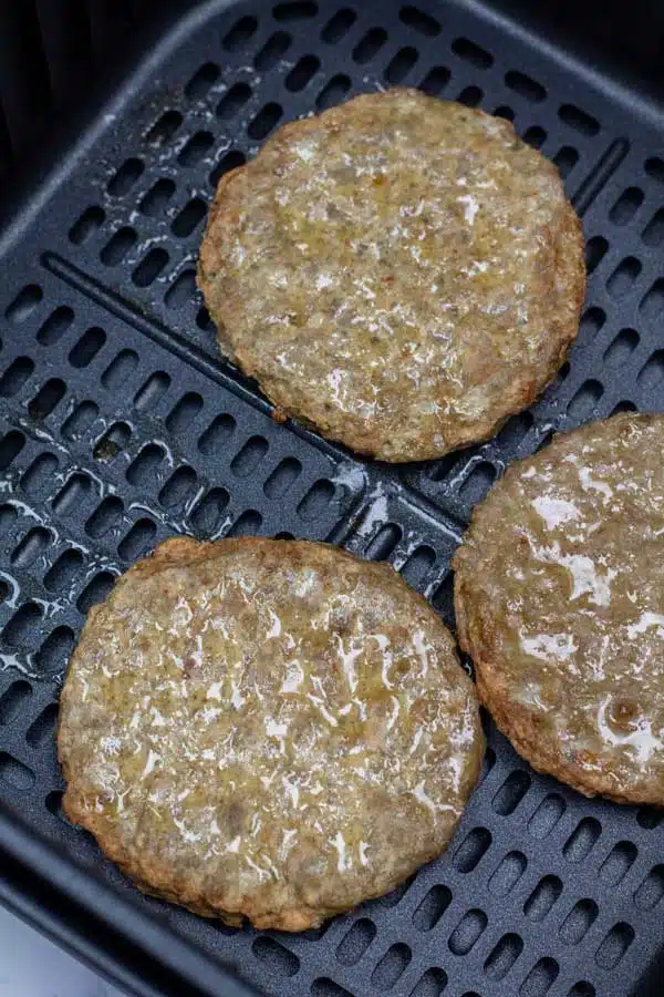 Process image 2 showing frozen sausage patties flipped over in the air fryer.