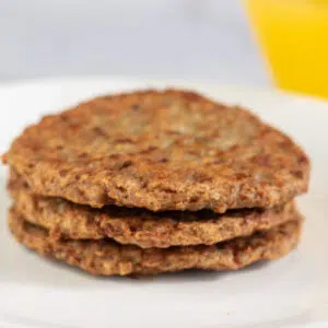 Close up square image of air fryer frozen sausage patties.