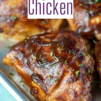 Pin image with text of bbq baked chicken thigh on a small baking sheet.
