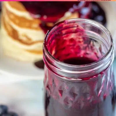 Pin image with text of blueberry syrup in a jar.