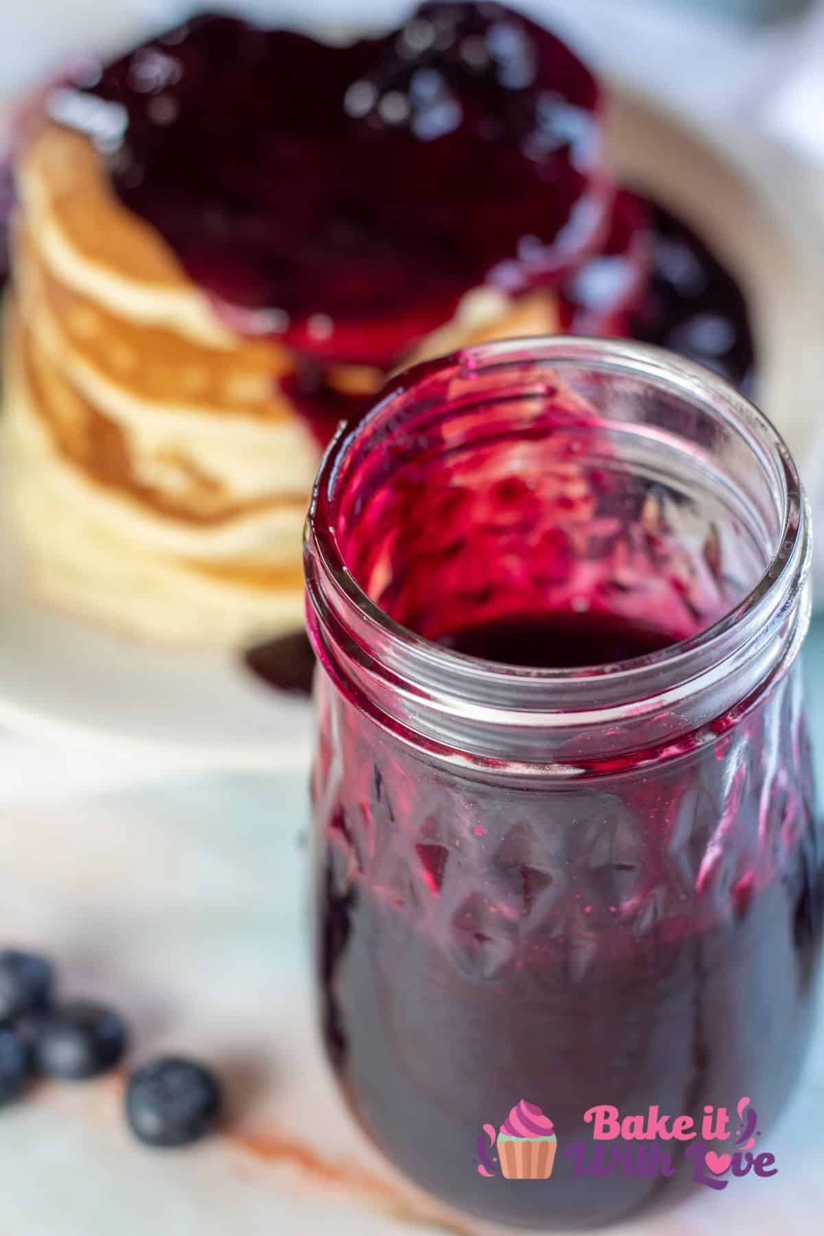 Tall image of blueberry syrup in a jar.