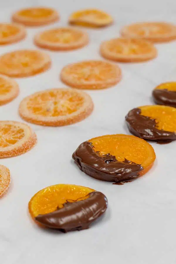 Process photo 10 showing candied oranges, some with chocolate on baking sheet.
