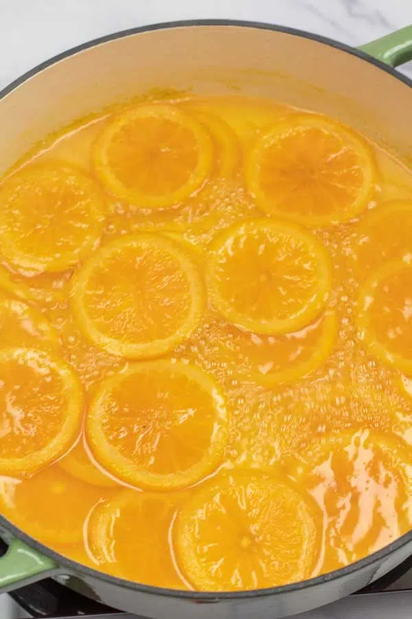 Process photo 3 showing sliced oranges cooking in large pot.