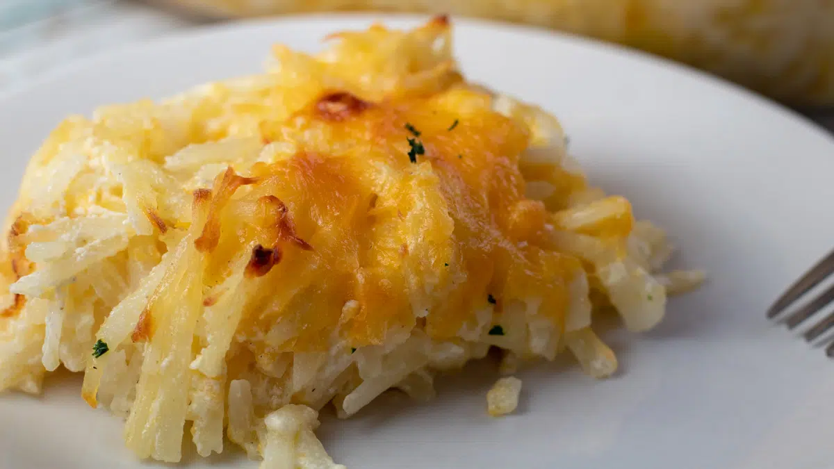 Wide image of Cracker Barrel Hashbrown casserole copycate on a white plate.