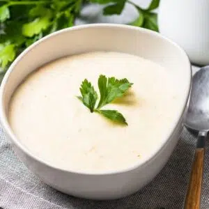 The best homemade cream of chicken soup in white bowl with parsley garnish.
