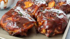 Wide image of bbq grilled chicken thighs.