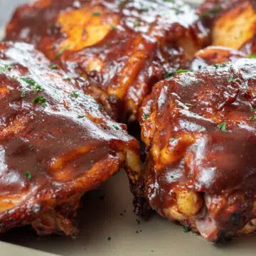 Wide image of bbq grilled chicken thighs.