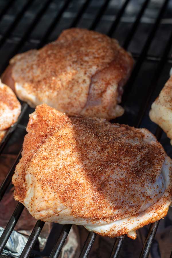 Process image 2 showing seasoned chicken thighs on the grill.