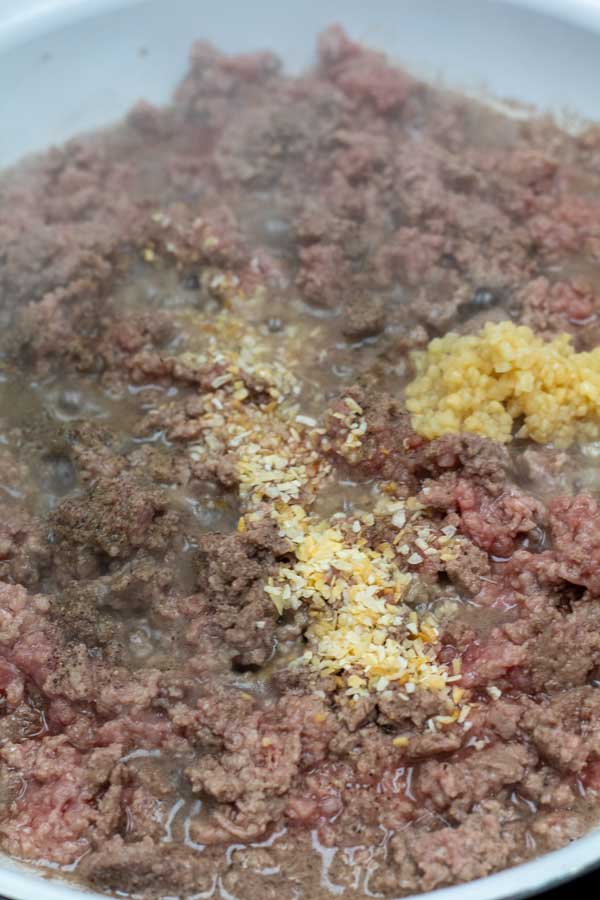 Process photo 5 showing ground beef cooking in pan with garlic and seasoning.