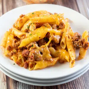 Closeup square image of ground beef casserole on a white plate.